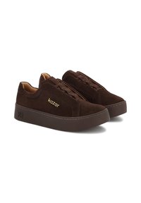 Tenisi maro din suede cu o talpă întunecată plată, având un design slip-on, detalii de cusătură subtile și branding auriu "kazar" pe lateral.