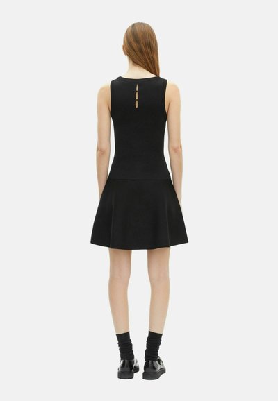 Robe noire sans manches avec un corsage ajusté et une jupe évasée, dotée de trois boutons à l'arrière et d'un tissu lisse et texturé.