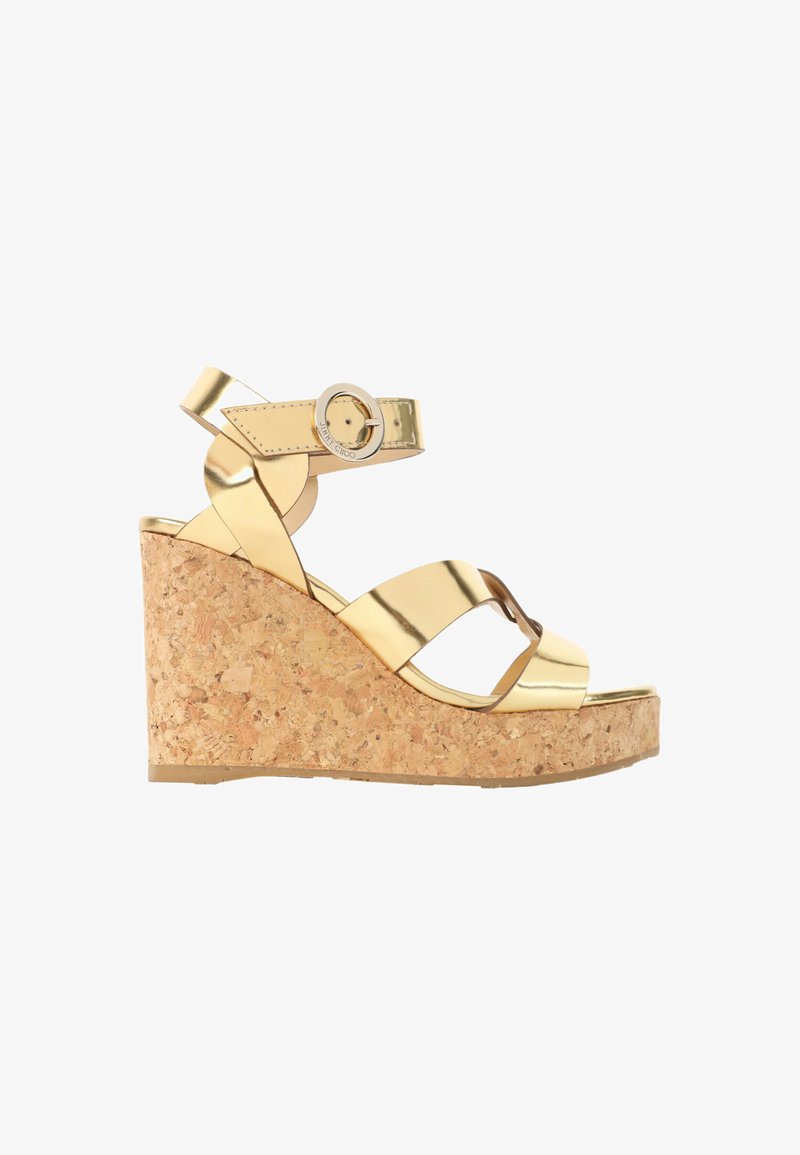 Sandale compensée métallique dorée avec brides croisées, boucle réglable à la cheville et semelle plateforme en liège.