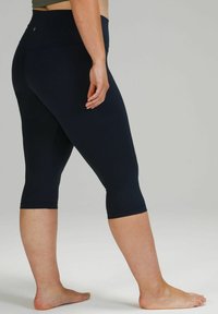 Leggings capri navy en matière extensible, dotés d'une taille haute et d'une finition élastique à l'ourlet, avec une texture lisse.