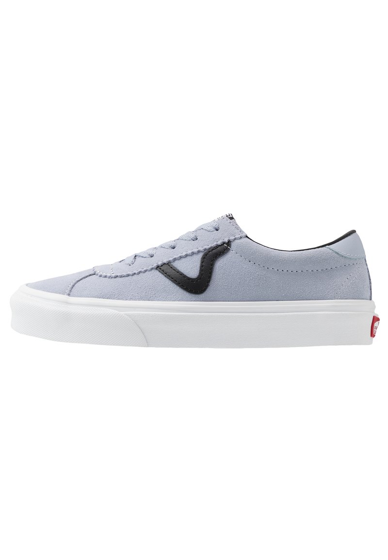 Zapatilla de ante gris claro con acentos negros, suela de goma blanca y costuras contrastantes; diseño de cordones, perfil bajo y logo en el talón.