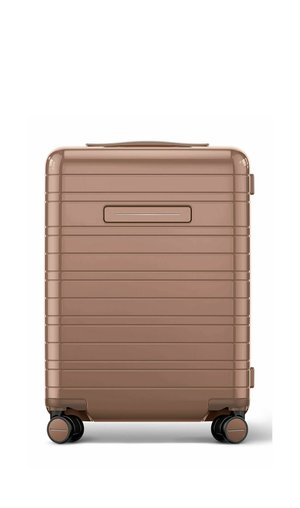 Hard-shell bronze suitcase with four black spinner wheels and horizontal ridges on its exterior.