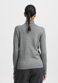 Pull en maille grise à col roulé avec des manches longues et un ourlet côtelé, montrant la vue arrière et la texture du tissu sur un fond uni.