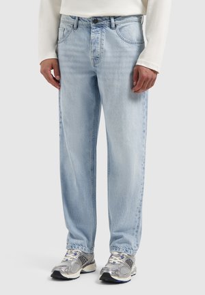 Lichtblauwe denimjeans met een ontspannen pasvorm, zichtbare stiksels, vijf-pocket ontwerp en een knoopsluiting bij de taille. Draag met grijze sneakers.