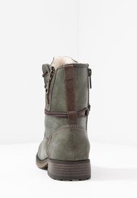 Zielona skórzana botka do kostki o teksturowanym wykończeniu, z brązowymi akcentami, z bocznym zamkiem błyskawicznym i okrągłym noskiem. Gruba podeszwa zapewniająca wsparcie.