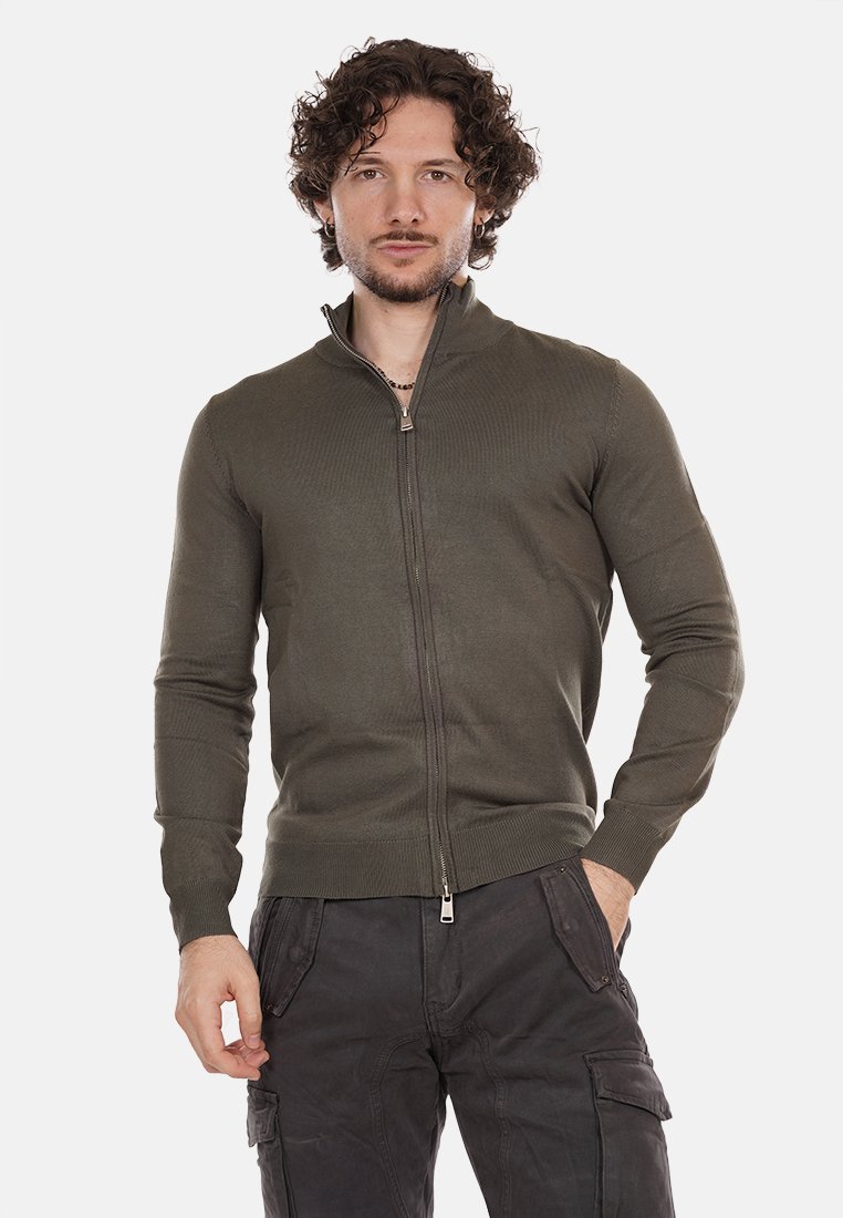 Pullover verde oliva con cerniera, caratterizzato da una texture a coste e colletto alto. Presenta una cerniera in metallo e una vestibilità aderente ai polsini e in vita.