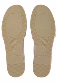 Zapatos planos con una parte superior de color rosa claro y suela de goma beige texturizada, que cuenta con ranuras para mayor tracción y detalle en relieve "Fabricado en España".