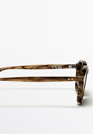 Bruine schildpadzonnebril met een robuust montuur, platte pootjes en tekst "P CATEGORY 3" op de binnenkant van het montuur.