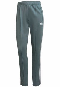 Pantaloni sportivi verdi a vestibilità slim, realizzati in un tessuto liscio, con strisce laterali bianche e tasche con zip per la sacca.