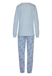Svetlomodrá blúzka s dlhým rukávom v kombinácii so svetlomodrými nohavicami s motívom teddy medvedíka a hviezd; oboje vyrobené z jemnej bavlny.