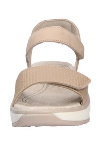Sándalo beige con dos correas ajustables, parte superior texturizada, plantilla acolchada y suela blanca con un patrón. La vista frontal muestra un diseño de punta abierta.