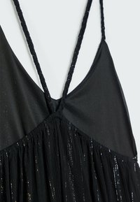 Robe noire sans manches avec fines bretelles tressées et tissu brillant froncé sous la poitrine.