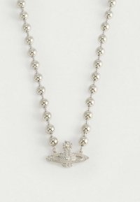 Silverfärgat pärlhalsband med ett glittrande planetformat hänge prytt med ett kors på toppen, mot en enfärgad vit bakgrund.