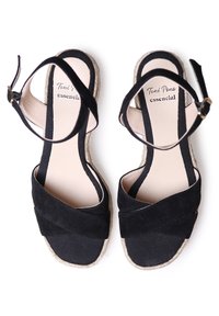 Sandali espadrilles in suede neri con cinghie incrociate, suola in juta naturale e una morbida soletta beige. Cinghie alla caviglia regolabili con hardware dorato.