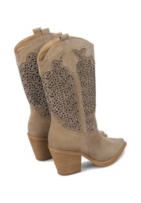 Botas de vaquero beige con un diseño decorativo de cuentas en el caña, material de ante sintético, punta afilada y tacón apilado.