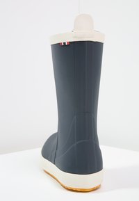 Tmavo modré nepremokavé čižmy s bielou podrážkou a textúrovaným vzorom. Obsahujú zadnú pútko a červené, biele a modré akcenty blízko vrchu.