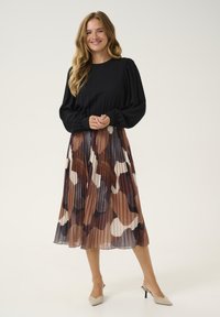 Black long-sleeve blouse with gathered shoulders paired with a pleated midi skirt in brown tones and abstract white, cream, and gray patterns.