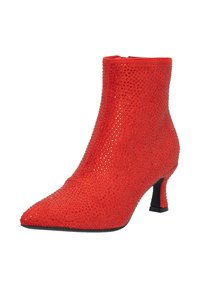 Botín rojo hasta el tobillo con punta afilada, cubierto de pequeños brillantes que destellan, con un tacón bajo y una textura de tela suave.