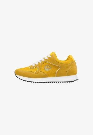 Gelber Wildleder-Sneaker mit weißen Schnürsenkeln, weißer Sohle, schwarzer gezackter Außensohle und kleinem grauem Logo an der Seite.