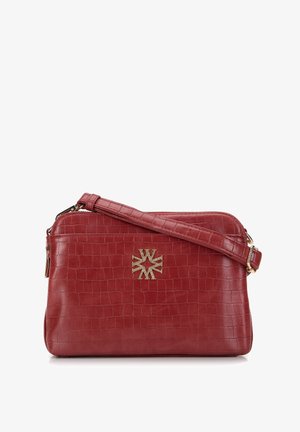 Czerwona skórzana torebka na ramię z teksturą krokodyla i złotym emblematem umieszczonym na przodzie, z regulowanym paskiem i zapięciem na zamek.