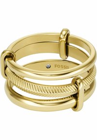 Pile de trois bagues dorées avec des anneaux lisses et texturés, avec de petits accents rectangulaires et un nom de marque avec une petite pierre précieuse à l'intérieur d'une bague.