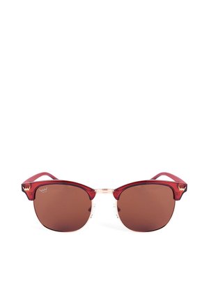 Rote Cat-Eye-Sonnenbrille mit braunen Gläsern, klarer Vorderbrücke und kontrastierenden roten Bügeln, die ein markantes Logo am Tempel haben.