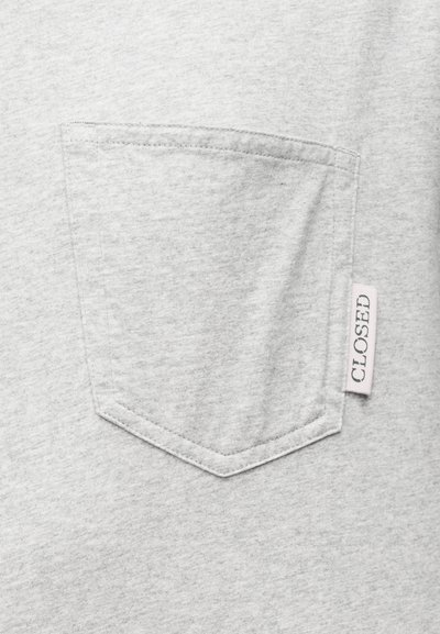 Γκρι βαμβακερό T-shirt με τσέπη στο στήθος που έχει ραμμένο περίγραμμα και ετικέτα με την ένδειξη "CLOSED" στο πλάι. Απαλή, λεία υφή.