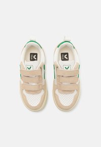 Sneakers beige e bianchi con dettagli verdi, realizzati in mesh e suede. Presentano tre cinturini in Velcro e un tallone rinforzato per una facile calzata.