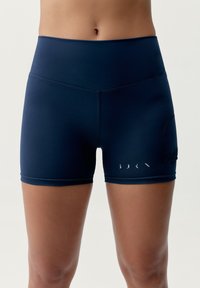Shorts deportivos de alta cintura en color navy, hechos de una tela suave y elástica, con un bolsillo lateral y un detalle de texto minimalista en el dobladillo.