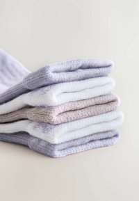 Una pila de seis pares de calcetines, que presentan un degradado de púrpura claro, lavanda y blanco. Tela de punto texturizada con puños enrollados.