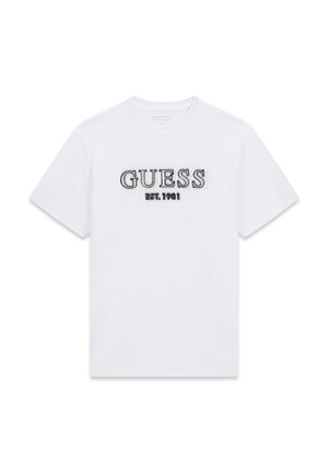 T-shirt en coton blanc avec "GUESS" brodé en noir, et "EST. 1981" en texte plus petit en dessous. Design classique à col rond.