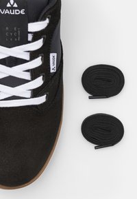 Czarne zamszowe sneakersy z białymi sznurówkami i gumową podeszwą; zawierają dwie czarne wymienne sznurówki do personalizacji. Posiadają metkę z logo.