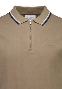 Beige Polohemd mit halbem Reißverschluss, Kragen mit marineblauen und weißen Streifen und kleinem gesticktem Logo auf der linken Brust.