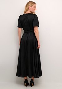 Rochie maxi din satin negru, cu mâneci scurte tip puff, talie ajustată și fustă fluidă. Include o curea asortată și o cu seamă pronunțată la spate.