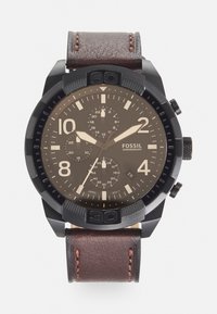 Schwarze Chronographuhr mit braunem Lederarmband. Verfügt über große arabische Ziffern, drei Unterzifferblätter und eine strukturierte Lünette.