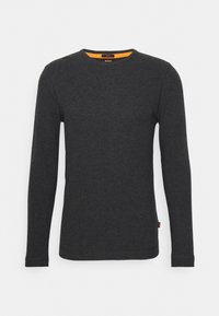 T-shirt à manches longues en coton gris foncé avec un col rond. Présente des accents orange à l'intérieur du col et une étiquette en bas.