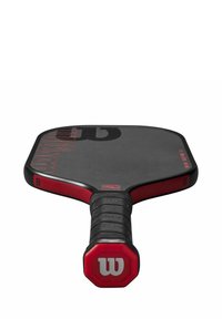 Zwarte en rode pickleballpaddle van het merk Wilson met een gestructureerde grip en een octagonale handgreep, met het witte "W" logo zichtbaar aan het uiteinde.