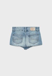 Short en denim bleu clair avec deux poches arrière comportant des coutures blanches et marron et une petite étiquette de marque rectangulaire en cuir.