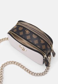 Malá růžová kabelka se zlatým kováním, s černým vzorovaným popruhem a dvojitými zipy. Součástí je řetízkový popruh pro všestranné použití.