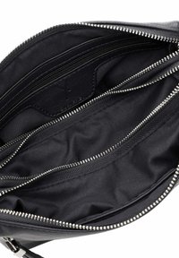Pochette in tessuto nero con dettagli della cerniera argentata, dotata di più scomparti e foderata con un interno liscio. Nessuna tasca esterna visibile.