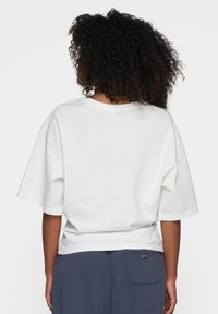 Witte katoen T-shirt met een ontspannen pasvorm, wijde mouwen en een cropped zoom. De achterkant toont een eenvoudig ontwerp zonder zichtbare patronen of accenten.