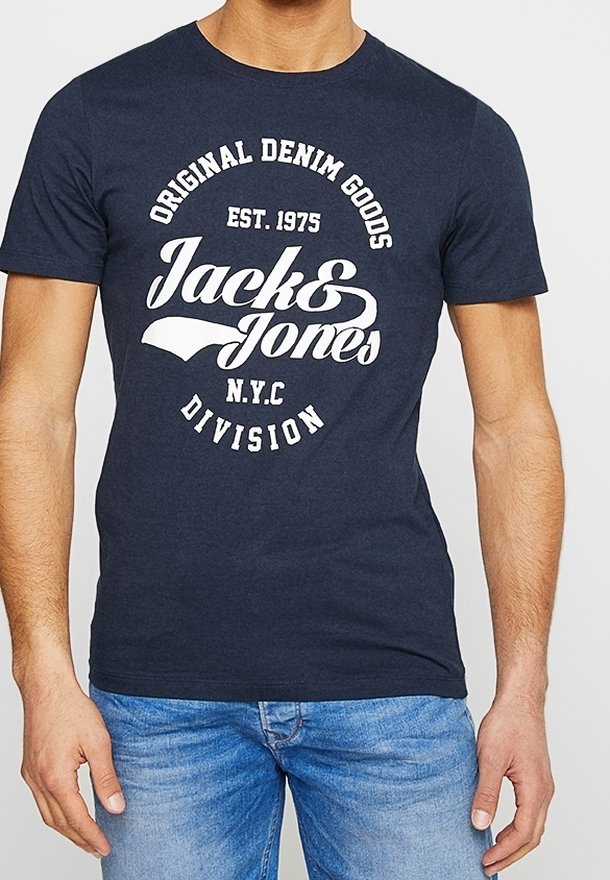 Camiseta azul marino con el texto blanco del logo "Jack & Jones", usada por una persona con jeans azul claro, cortada en el cuello y a mitad del muslo.