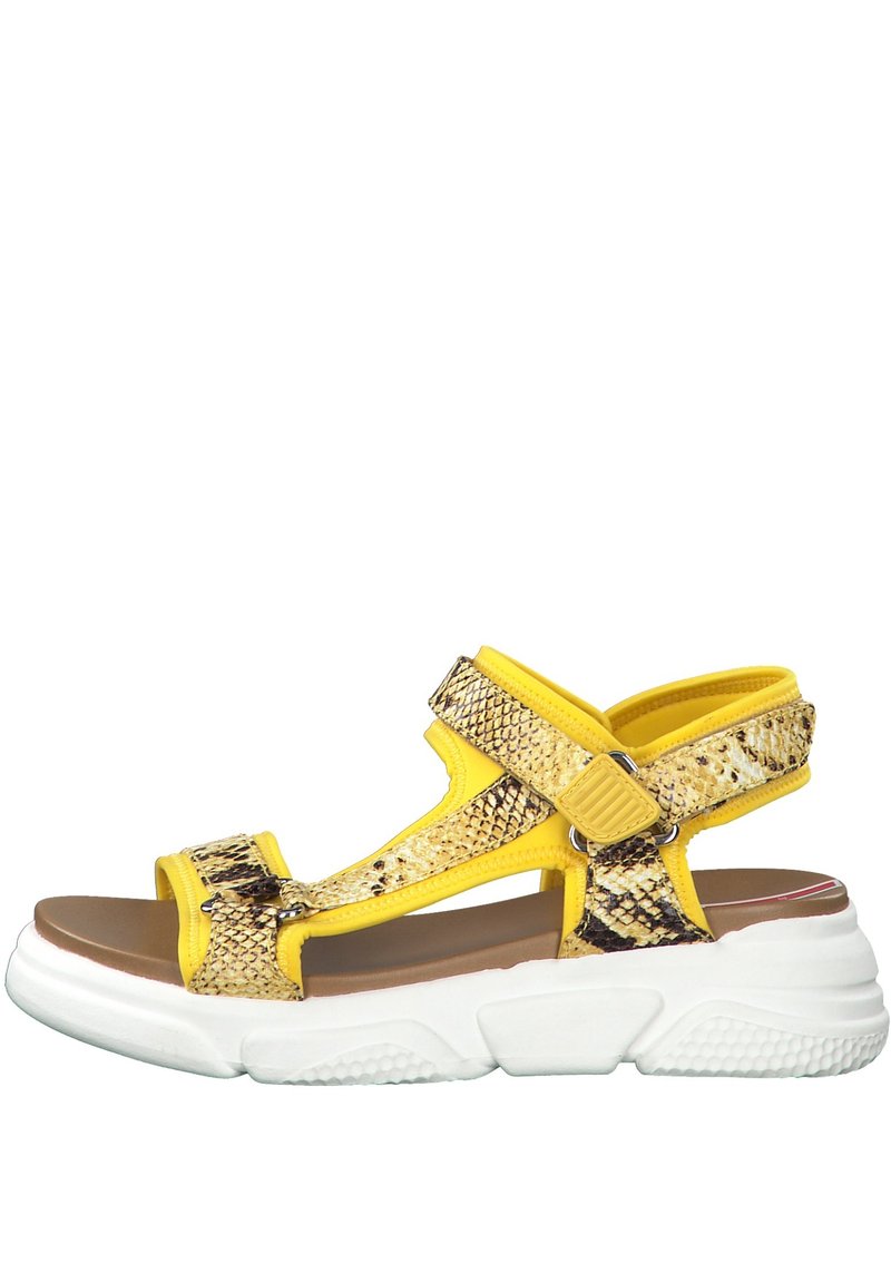 Yellow snake print sandals feature adjustable straps, a padded footbed, and a thick, white rubber sole with textured grip.