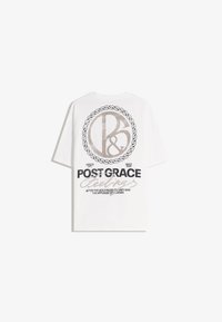Maglietta a maniche corte bianca in cotone con una grande grafica che mostra "B&R" all'interno di un cerchio intrecciato e il testo "POST GRACE" in accenti neri e dorati.