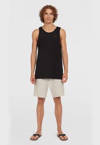 Sort ærmeløs tanktop med rund halsudskæring, lyse beige shorts og brune flip-flops, stående på en ensfarvet hvid baggrund.