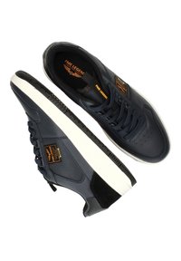 Marine leren sneakers met een witte rubberen zool, platte veters en zwarte accenten. Voorzien van een logo-opdruk aan de zijkant en perforaties op de neus.