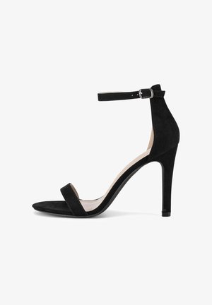 Sandal alto in suede nero con cinturino sottile alla caviglia, punta aperta e soletta sagomata. Il tacco è snello ed elevato.