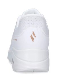 Sneaker bianca con design perforato sulla parte superiore, dotata di una suola bianca testurizzata e di un piccolo logo metallici rosa oro sul tallone.