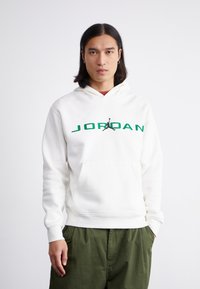 Fehér kapucnis pulóver zöld "JORDAN" felirattal és fekete Jumpman logóval. Kenguruzseb; bordás mandzsetta és szegély; puha tapintás.