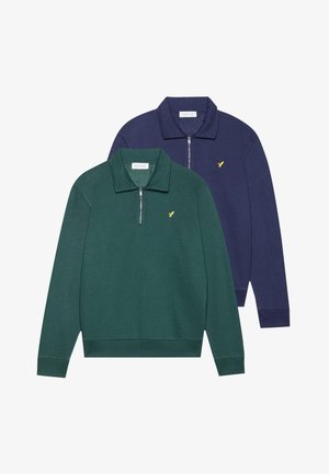 Duas sweatshirts com fecho éclair em verde escuro e azul-marinho. Ambas apresentam colarinho, punhos elásticos e um pequeno logótipo amarelo no peito. Tecido macio.